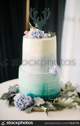 Big white wedding cake with fruit is on the table close up. Big white wedding cake with fruit is on the table