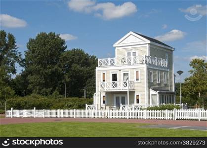 big wooden house with blue sky and white clouds