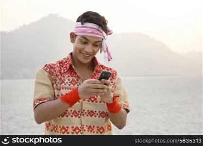 Bihu man reading an sms on a mobile phone