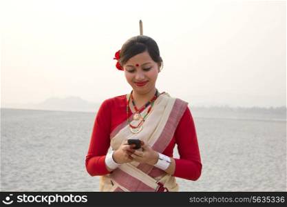 Bihu woman reading an sms on a mobile phone