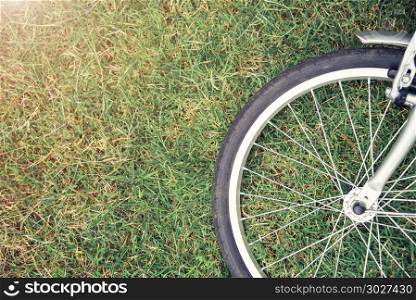 Bike concept background. Close up of bike wheel on green grass w. Bike concept background. Close up of bike wheel on green grass with sunlight. Sport and healthy. Picture for add text message. Backdrop for design art work.