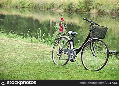 Bike placed in grass at the riverside