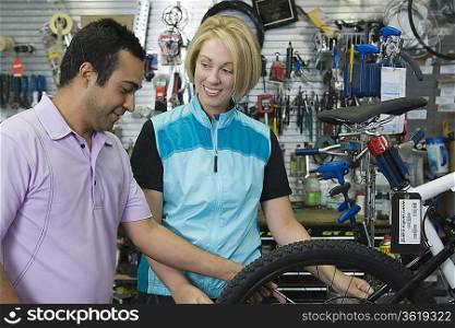 Bike shop assistant helps female cyclist