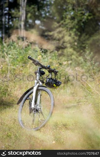 Bike tour. Bike, grass and wood. Outdoors, text space