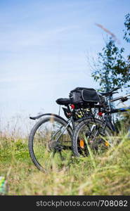 Bike tour: Bikes, grass and blue sky. Outdoors, text space