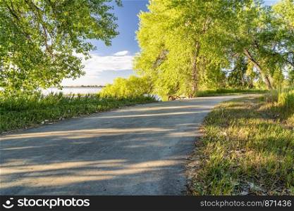 bike trail on a shore of Boyd Lake in Colorado, morning summer scenery