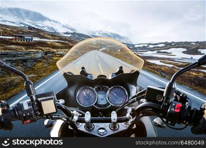 Biker First-person view, mountain pass in Norway. Biker rides a motorcycle on a slippery road through a mountain pass in Norway. Around the fog and snow. First-person view.