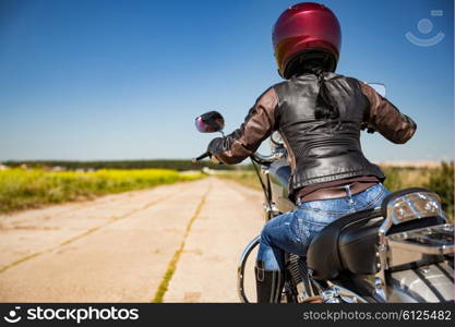 Biker girl rides a motorcycle in the rain. First-person view.