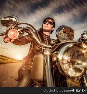 Biker girl with sunglasses sitting on motorcycle
