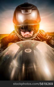 Biker in helmet and leather jacket racing on the road