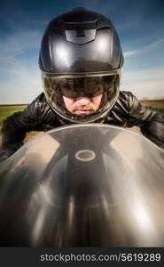 Biker in helmet and leather jacket racing on the road