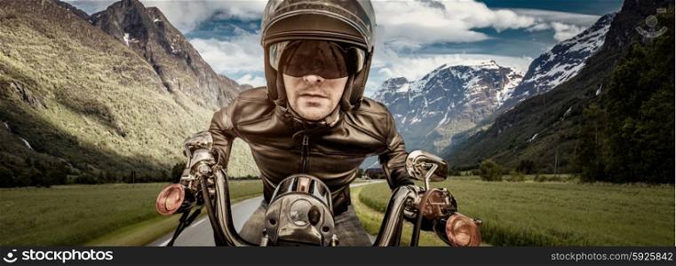 Biker in helmet and leather jacket racing on the road.