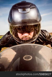 Biker in helmet and leather jacket racing on the road