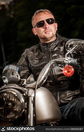 Biker in sunglasses and a leather jacket on a motorcycle