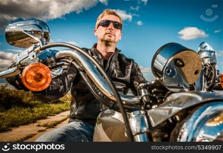 Biker in sunglasses and a leather jacket on a motorcycle