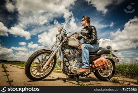 Biker in sunglasses and leather jacket on the road