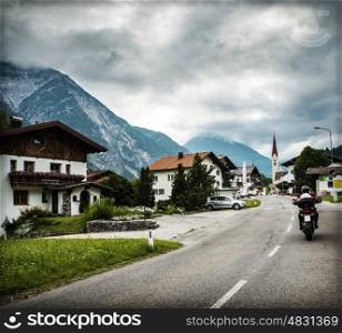 Biker on the road in Alps, extreme sport, moto tour along European mountains, beautiful landscape, travel and tourism concept