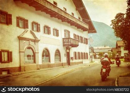 Bikers in European city, beautiful retro style photo, grunge image, spending vacation on mountains, extreme adventure, active touring concept