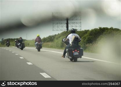 Bikers riding on the road through the water from the windshield