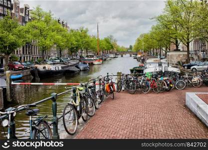 Bikes and boats along the canal in Amsterdam, Netherlands, North Holland province.