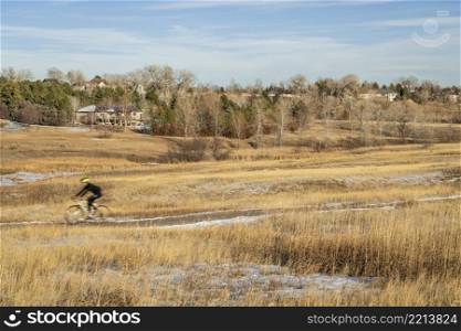 biking trail in Fort Collins, Colorado with a motion blurred cyclist, warm calm winter afternoon, Cathy Fromme Prairie Natural Area