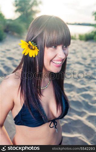 Bikini female with sunflower in her long black hair