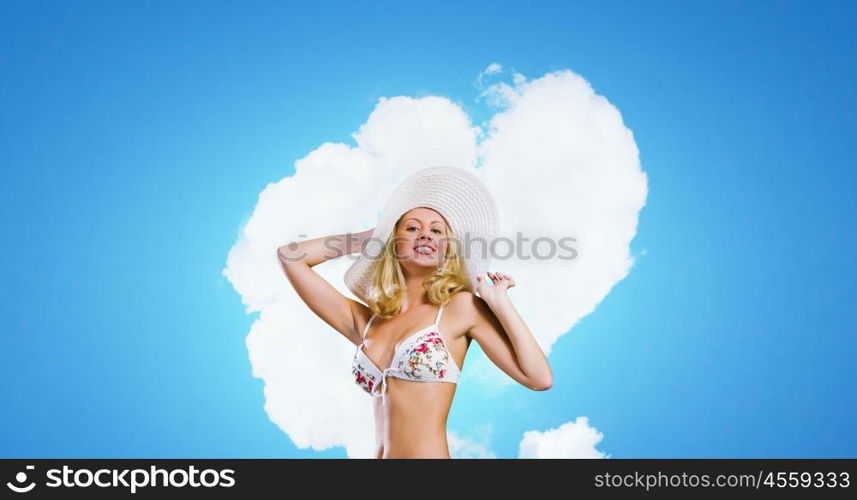 Bikini girl. Beautiful blond girl in hat and white swimsuit bikini