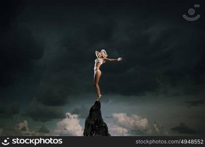 Bikini girl. Hot young dancing woman in white bikini on dark background
