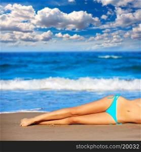 bikini girl legs lying on beach sand in summer vacation