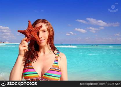 bikini tourist redhead woman holding starfish tropical beach