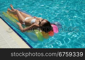 Bikini Woman on Air Bed In Swimming Pool Long shot