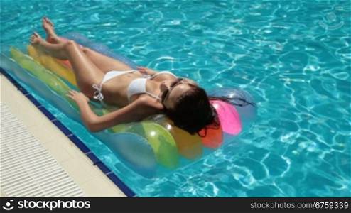 Bikini Woman on Air Bed In Swimming Pool Long shot
