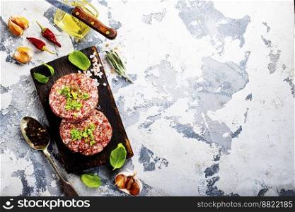 Billets for burgers from fresh minced meat with spices on a wooden board