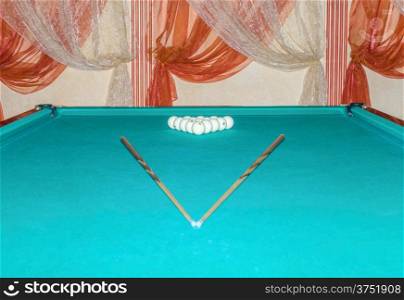 Billiard balls and cue on a billiard table. Shallow depth of field