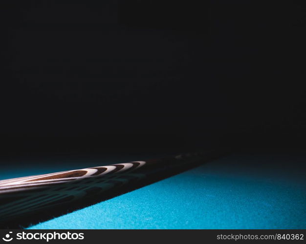 Billiard cue on a table. Close-up. Black background