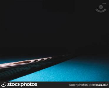 Billiard cue on a table. Close-up. Black background