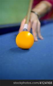 billiard yellow ball player hand holding cue selective focus