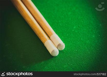 Billiards cue sticks on green table. Pool game. Cue sticks on green billiard table