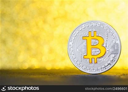 Bincoin coin on black table with gold bokeh background and copy space