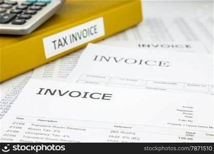 Binder of tax invoice documents with bills and business invoices on background