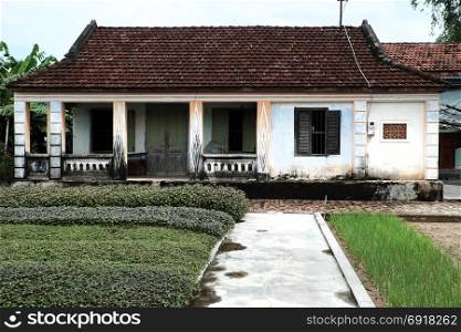 BINH DINH, VIET NAM- NOV 2, 2017: Vietnamese ancient house with wood door, wooden window and vegetable garden in front of, the old home with traditional architecture on day, Vietnam