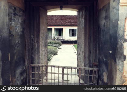 BINH DINH, VIET NAM- NOV 2, 2017: Vietnamese ancient house with wood door, wooden window and amazing big concrete gate, the old home with traditional architecture on day, Vietnam