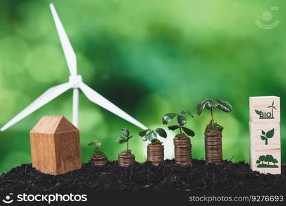 Bio energy symbol with seedling on coin stack and wind turbine. Eco financial growth using clean energy for green environment. Sustainable investment on reducing pollution and CO2 emission. Alter