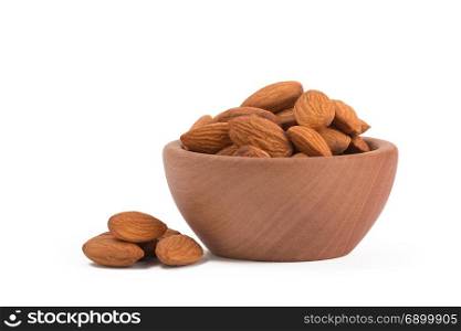 Bio organic almonds in wooden bowl isolated on white background.. Bio organic almonds in wooden bowl isolated on white background,