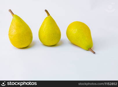 Bio pears lined up. Geometric composition of yellow pears on white background