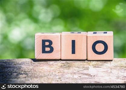 Bio sign in green nature on a wooden log