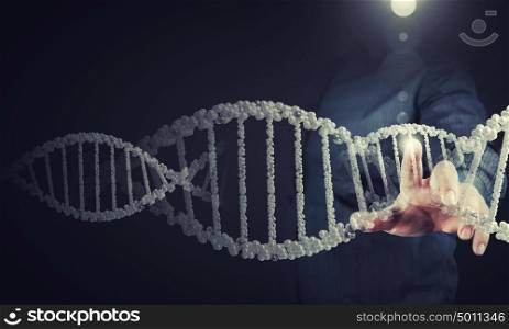 Biochemistry research. Science concept image of human hand touching DNA molecule