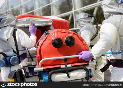 Biohazard medical team pushing stretcher towards decontamination chamber