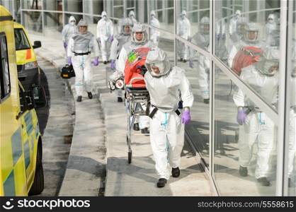 Biohazard team with stretcher wear protective uniform walking outside building