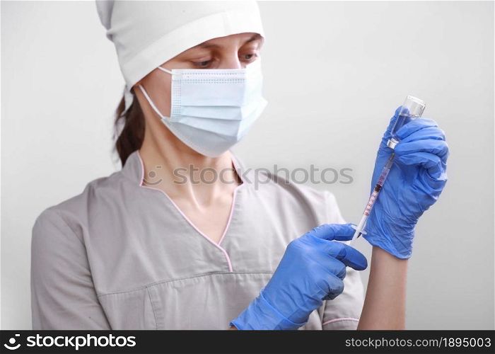 Biological hazard. Epidemic of the Chinese coronavirus. Doctor, nurse, scientist in a protective suit and mask holds an injection syringe and vaccine. Vaccine from, flu, coronavirus, ebola, TB. Biological hazard. Epidemic of the Chinese coronavirus. Doctor, nurse, scientist in a protective suit and mask holds an injection syringe and vaccine. Vaccine from, flu, coronavirus, ebola, TB.
